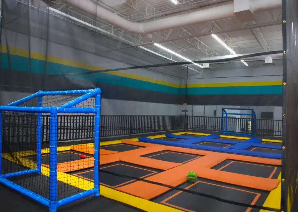 A trampoline park with many different colored walls.