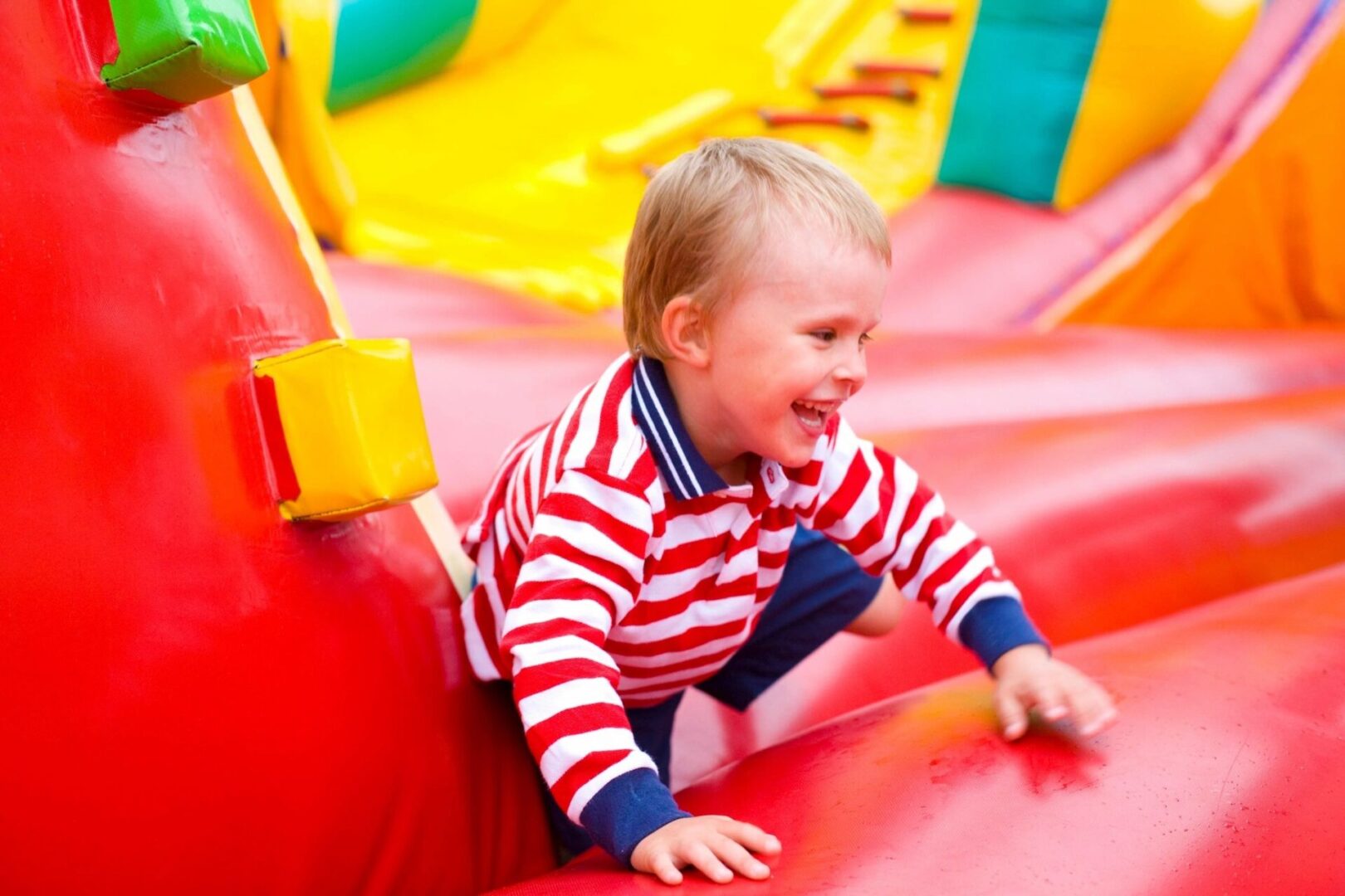 A toddler playing in the fun park and smiling