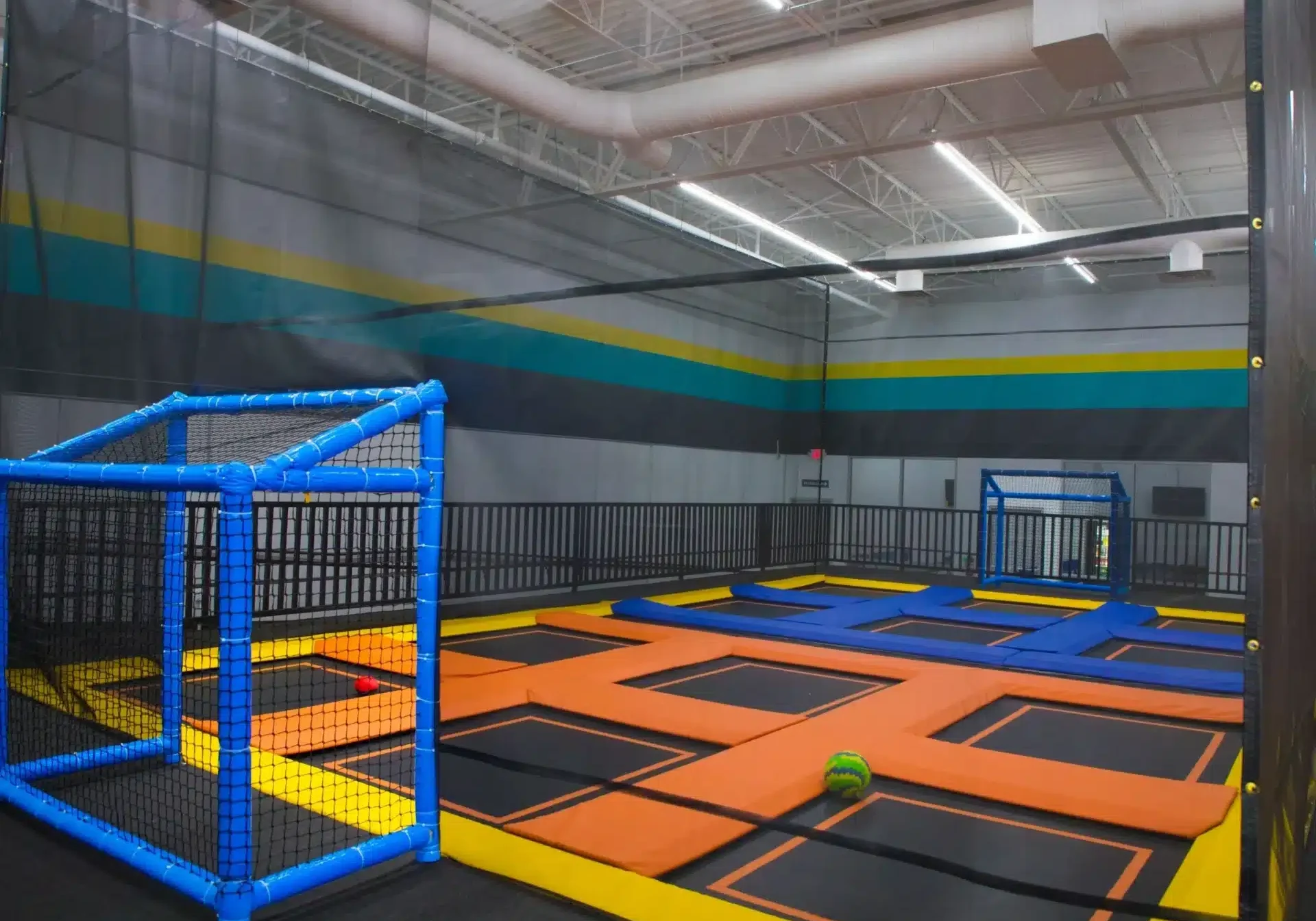 A trampoline park with many different colored walls.